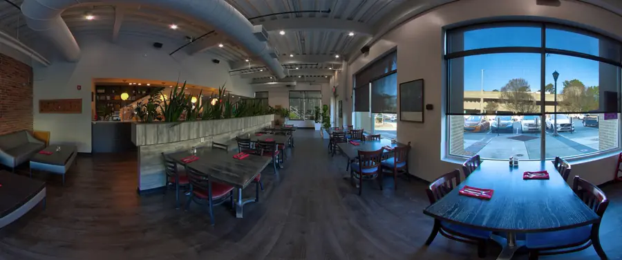 Dining room with tall windows and plant-lined divider